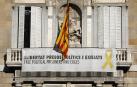 Vista del cartel reclamando la libertad de los líderes independentistas presos y un lazo amarillo en la fachada del Palau de la Generalitat.
