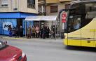 Vecinos esperan en una parada de autobús en Peralta