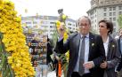 El presidente de la Generalitat, Quim Torra, coloca una rosa amarilla en el mural que recuerda a los independentistas presos instalado por Ómnium Cultural con motivo de la Diada de Sant Jordi.