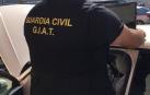 Un agente de la Guardia Civil, durante la operación, junto a uno de los vehículos.