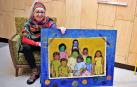 Miren Atxaga, mostrando una de las coloristas obras de su exposición.