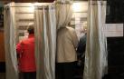 Dos personas preparan sus votos en una cabina durante las elecciones del 28A