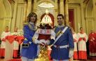 Dos policías municipales, con el uniforme de gala, depositan un ramo de seis rosas ante la imagen de San Fermín.