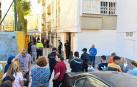 Vecinos de la barriada de Los Rosales y agentes de la Policía Nacional, a las afueras de la vivienda en la que ha tenido lugar el suceso.