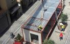 Varios operarios colocan los módulos del edificio en la calle Tafalla.