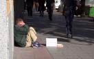 Una persona pide dinero en la calle.