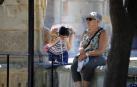 Una turista se refresca en una de las fuentes del patio de los Naranjos de la Mezquita-Catedral de Córdoba.
