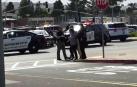 Varios policías ayudan a los ciudadanos tras el tiroteo en el centro comercial de San Bruno, en San Francisco.