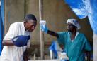 Foto de dos trabajadores sanitarios toman las medidas necesarias ante la epidemia de ébola detectada en el país.