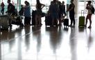 Varias personas esperan en el aeropuerto del Prat, Barcelona.