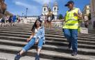 Una miembro de la Policía Municipal romana pide a una turista que no se siente en las escaleras de la Plaza de España.