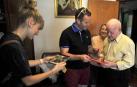 Javier Ezquerro entrega a Gregorio Armendáriz el pañuelico de fiestas del centenario.