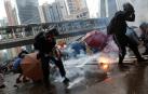 Manifestantes se defienden del gas lacrimógeno de la policía en Hong Kong.