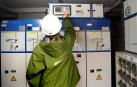 Un técnico revisa el cuadro de contadores eléctricos en una comunidad de vecinos.