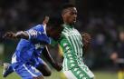 El centrocampista camerunés del Real Betis Kaptoum (d) protege un balón ante Djené, del Getafe.