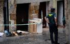 Agentes de la Guardia Civil junto a la vivienda de Laredo en la que han fallecido una mujer y su hija de 7 años a causa de un incendio.