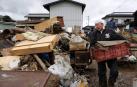 Un hombre transporta enseres afectados por las inundaciones en Nagano.