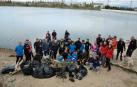 Los participantes posaron al final de la actividad con la basura recogida en el fondo y la orilla de la balsa.