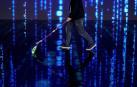 Un hombre limpia el suelo junto a una pantalla en la Conferencia Mundial de Internet en la localidad china de Wuzhen.