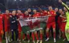 Bale y sus compañeros, con la bandera tras la celebración por la clasificación de Gales.