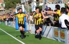 Arriba, aficionados de la Peña tras el muro celebran un gol de su equipo.