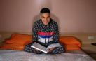 UN SUEÑO. Mohamed Ounasser, de 17 años, posa en su cama con un libro de electrónica. Su sueño ahora es continuar estudiando. En enero empezará la ESO.