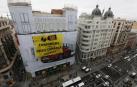 Greenpeace coloca una gran pancarta en Gran Vía para criticar el consumo "masivo"