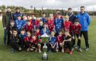 El colegio  Virgen Blanca de Huarte (azul) y el Regina Pacis de Burlada (rojo) buscarán llevarse el Interescolar este lunes. Jugadores y entrenadores posan con la copa en Tajonar.