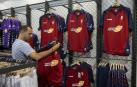 Un cliente examina la primera equipación de Osasuna, en la tienda de El Sadar, durante el verano.