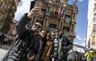 Unos turistas se hacen una foto delante del Ayuntamiento de Pamplona