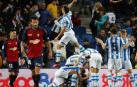 Rubén García y Roncaglia, cabizbajos, mientras los jugadores de la Real celebran uno de sus goles.