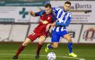 Barbero, delantero de Osasuna, intenta alcanzar el balón ante el defensa del Lorca Óscar Oliva.