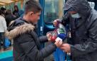 Un voluntario entrega una ración de comida a un niño refugiado e junto al campo de Moria.