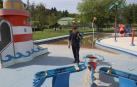 Un operario de mantenimiento del club deportivo Amaya, limpiando la zona de las piscinas infantiles.