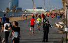 Policías municipales dan indicaciones a los ciudadanos que dan un paseo o hacen ejercicio por el Paseo Marítimo de Barcelona