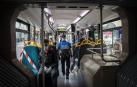 Dos policías municipales vigilan que la gente lleve mascarilla dentro del transporte público.