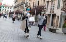 Dos jóvenes, con bolsas de compra, pasean por la calle Gaztambide-Carrera de Tudela.