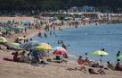 Varios bañistas se refrescan en la playa de Sant Feliu de Guixols.