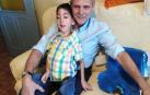 Sebastián Molina Ortiz, de 8 años, sentado sobre las piernas de su padre, Fernando Molina.