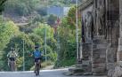 Dos personas acceden en bicicleta al entorno de Curtidores y contemplan la iglesia del Santo Sepulcro.