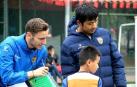 El navarro Javier Zudaire, a la izquierda, da órdenes con una pizarra a un futbolista del Chongqing.