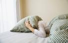 Una persona insomne se tapa con una almohada