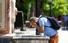 Un hombre se refresca en una de las fuentes del interior del Patio de los Naranjos de la Catedral de Córdoba