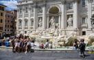 Varios turistas se fotografían en la Fontana de Trevi con mascarilla