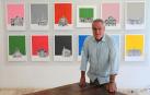 Iñaki Pardos posa junto a algunas de sus obras de fondos coloristas sobre edificios emblemáticos y reconocibles de Pamplona.