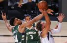 Antetokounmpo trata de bloquear a Doncic.