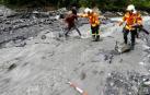 Bomberos suizos ayudan a cruzar a un periodista en la zona donde se busca al navarro desaparecido.