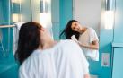 Una joven se seca el pelo en el cuarto de baño