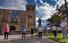 Algunos de los socios de la cofradía Amigos de San Veremundo en la entrada de la parroquia,  junto con la estatua del patrón de la localidad.