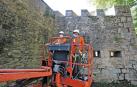Dos operarios de Leache mueven el vehículo para retirar las malas hierbas de las cañoneras y merlones del fortín de San Bartolomé.